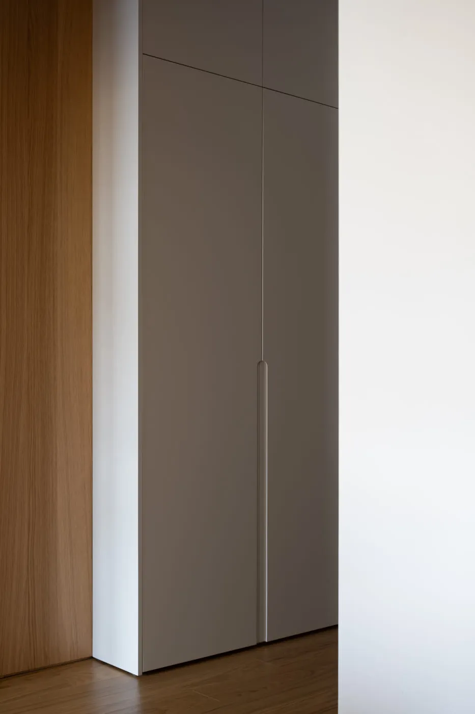 Detalj farbanog fronta sa glodanom ručkom izvedenom u samom frontu, uz toplu hrastovu površinu